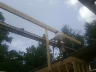 Carpenter setting a ridge beam over a new addition frame — Ice Dam Removal by Roofing Brothers in Pleasant Mount