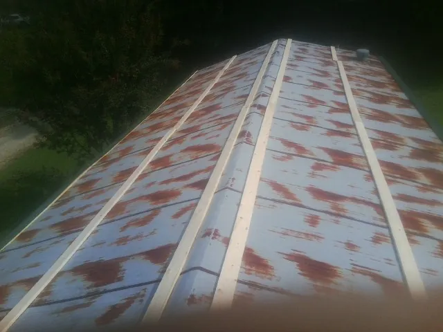 Rusted metal roof panels with new wood purlins before replacement — Storm Damage Roof Repair in Pleasant Mount by Roofing Brothers