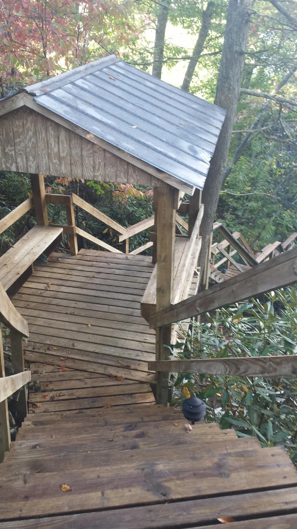 Metal roofed shelter over wooden steps on a wooded walkway — Skylight Repair & Installation work by our crew in Pleasant Mount
